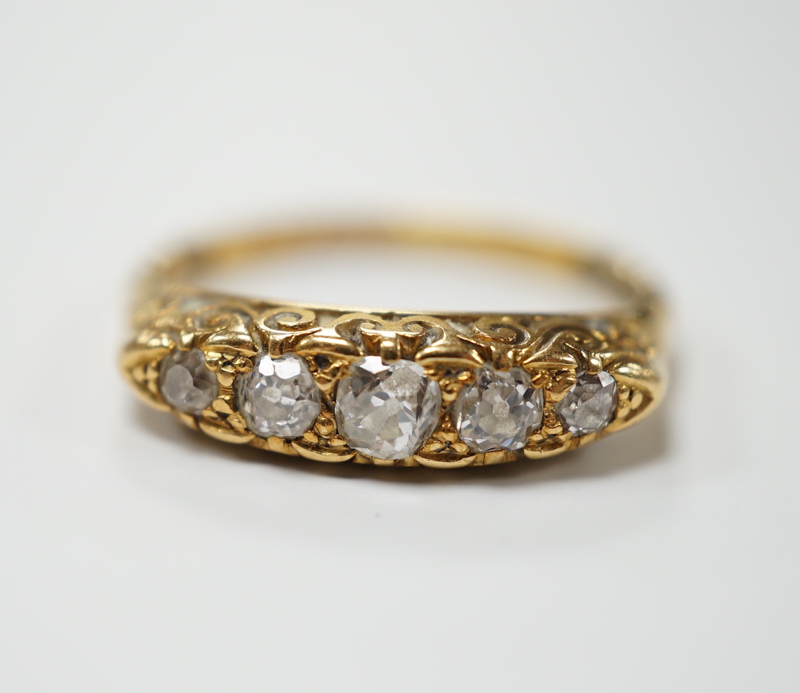 An Edwardian 18ct gold and graduated five stone diamond set half hoop ring. size R, gross weight 4.4 grams.